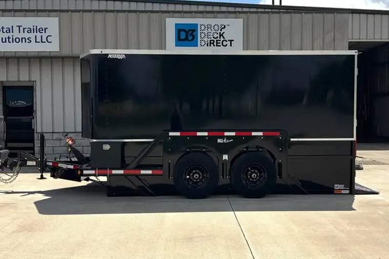 Enclosed hydraulic drop deck trailer parked outside the Total Trailer Solutions building