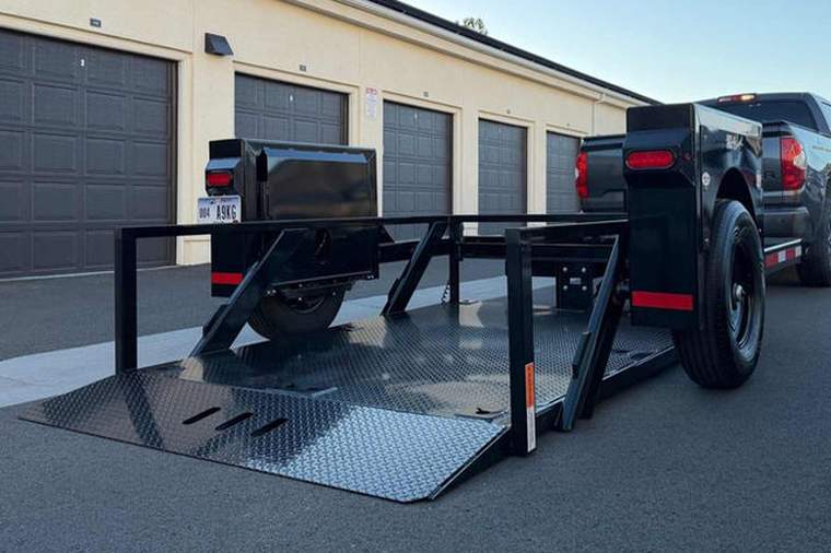 Single axle hydraulic drop deck trailer with the deck lowered to the ground